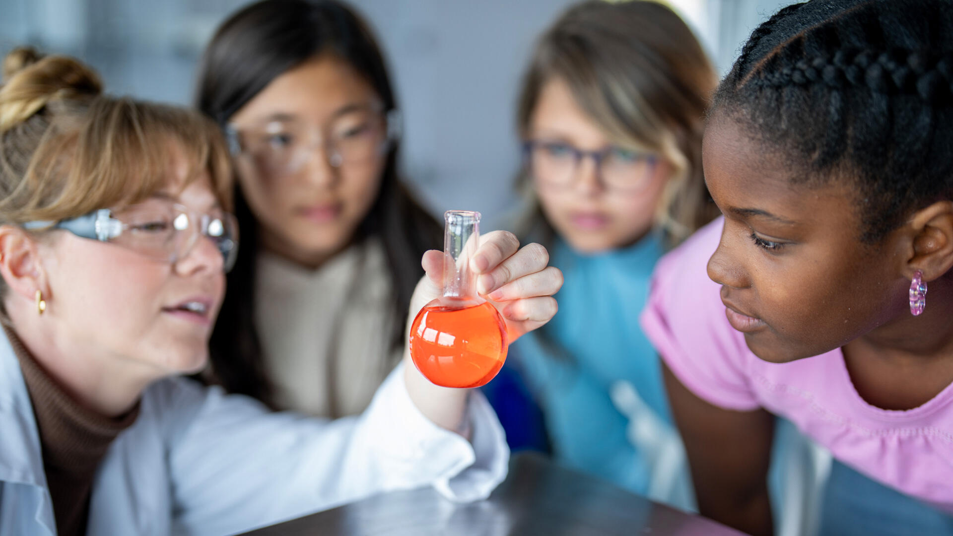 Kids and teacher looking at test tube