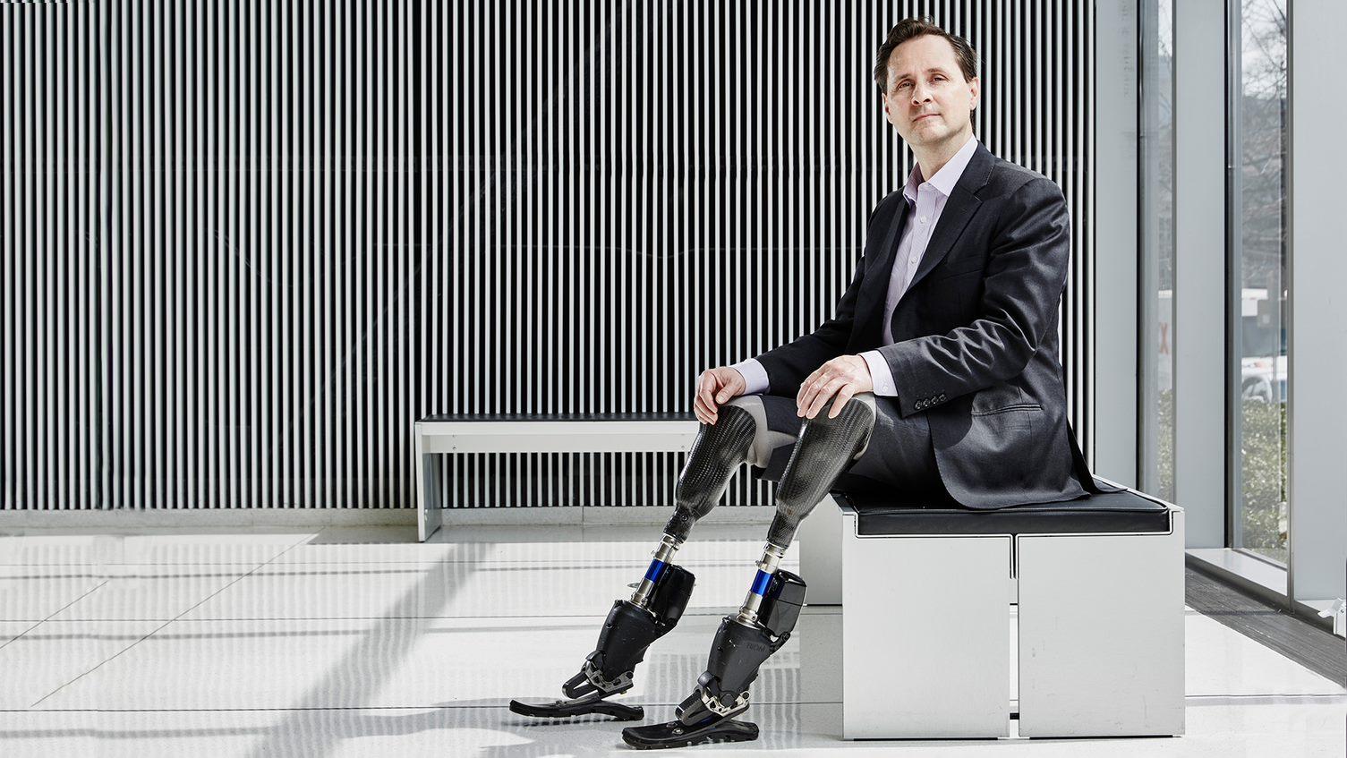 Inventor with biomechatronic legs sitting 