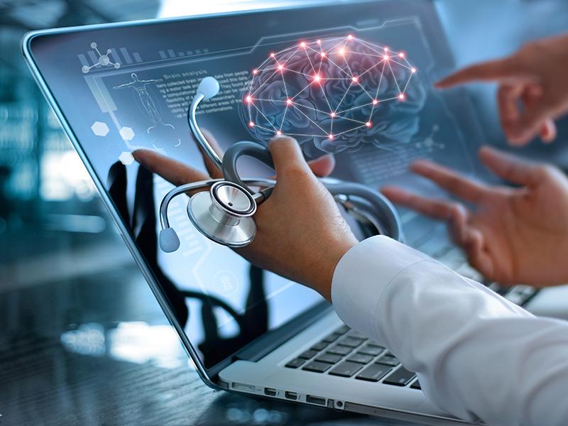 Person with stethoscope pointing at laptop screen, displaying a brain and other medical topics
